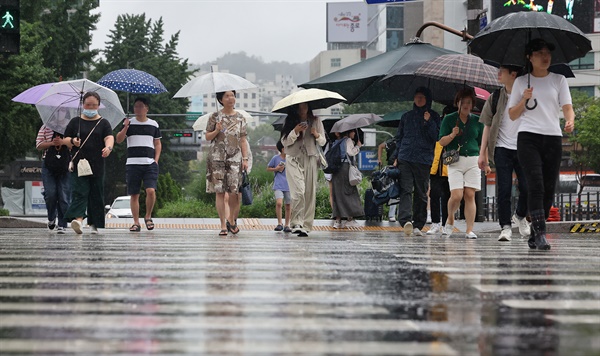 서울 전역에 호우주의보가 발효 중인 23일 오전 서울 광화문광장에서 시민들이 우산을 쓴 채 걸어가고 있다. 