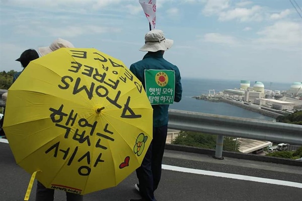 옥분 씨가 한일 탈핵연례 순례단과 함께  2016년 5월 '일본 이카타 핵발전소 재가동반대'를 위한 도보순례에 참가했다. 아랫쪽 해변가에  이카타 핵발전소가 보인다.   