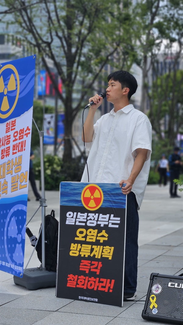 '일본 정부는 오염수 방류계획 즉각 철회하라!' 구호가 적힌 피켓을 들고 거리 발언을 하는 대학생.