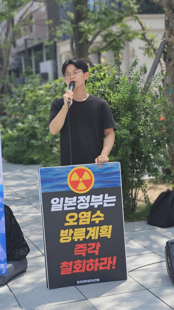 '일본 정부는 오염수 방류계획 즉각 철회하라!' 구호가 적힌 피켓을 들고 거리 발언을 하는 대학생.