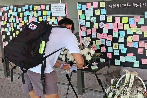 지난 7월 29일 충북 청주시 오송역 7번 출구에 마련된 오송 지하차도 참사 추모 공간을 지나던 한 시민이 추모 메시지를 적고 있다. 