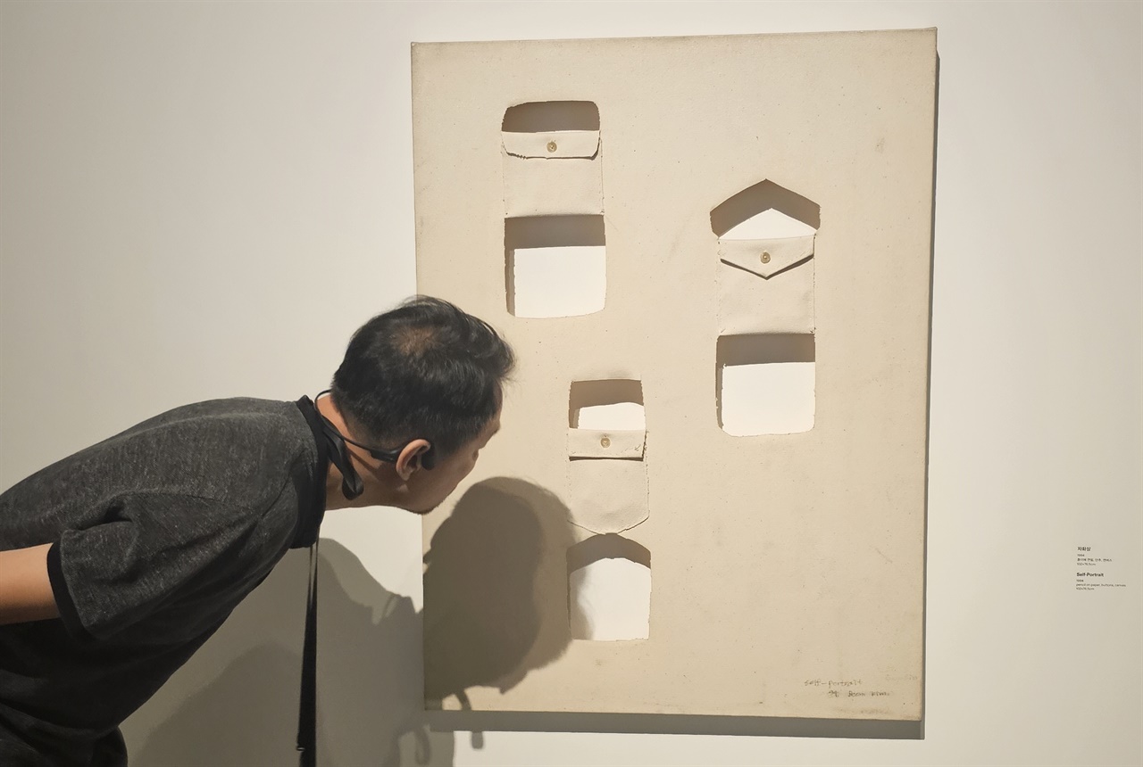     4일 리움미술관에서 열린 김범 개인전 ‘바위가 되는 법’을 찾은 필자가 작가의 '자화상'을 들여다보고 있다.