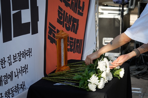 한 청년주거권실천단 단원이 기후재난 희생자를 추모하며 헌화하고 있다.