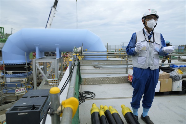 지난 7월 14일 마유즈미 토모히코 도쿄전력 대변인이 일본 후쿠시마 제1원전 앞에서 오염수 해양 방류 계획을 설명하고 있다.