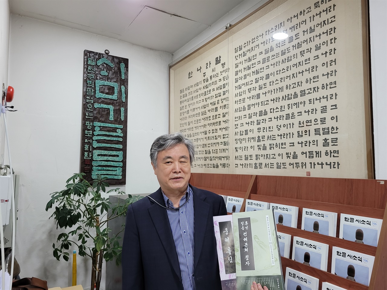 한글학회 1층, 주시경 선생이 1910년에 지은 ‘한나라말’ 앞에 선 허경무 서예가(2022년).