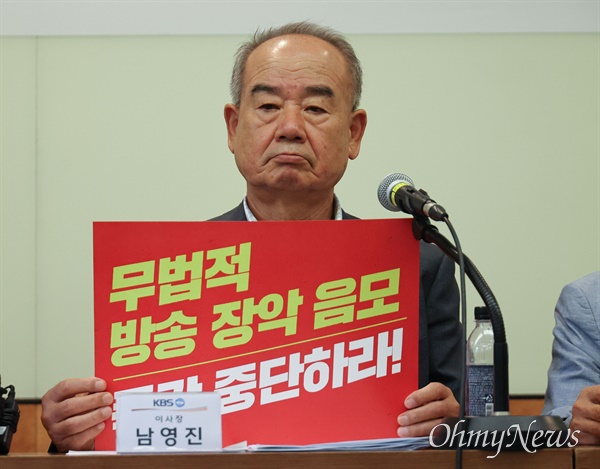 KBS 남영진 이사장이 ‘무법적 방송 장악 음모 즉각 중단하라’가 적힌 피켓을 들고 있다.