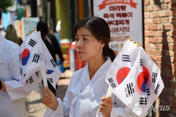 일제잔재청산 대구시민모임 소속 한 회원이 15일 대구 한일극장 앞에서 시민들에게 태극기를 나눠주고 있다.