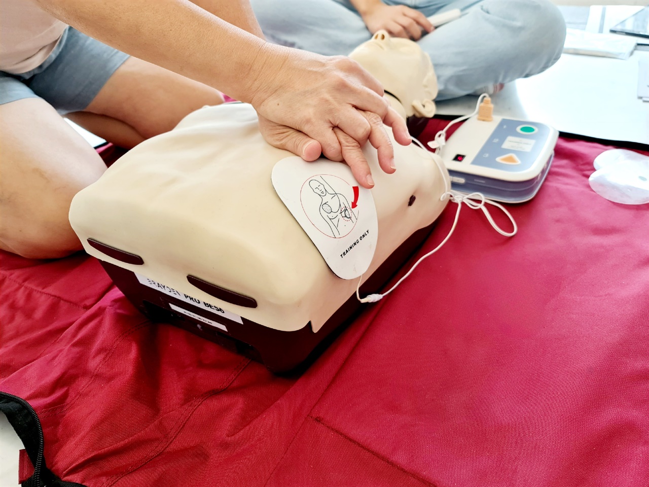 교육받던 날, 한 참가자가 자동심장충격기(AED)로 자동심장충격을 준 후 심폐소생술(CPR)을 시행하고 있는 모습.