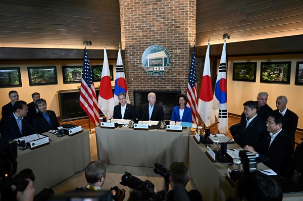 조 바이든 미국 대통령(가운데)이 앤서니 블링컨 미국 국무장관(가운데 왼쪽), 지나 라이몬도 미국 상무장관(가운데 오른쪽)과 함께 2023년 8월 18일 메릴랜드주 캠프 데이비드에서 기시다 후미오 일본 총리, 윤석열 한국 대통령과 3국 정상회의에 참석해 있다. 