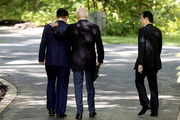 왼쪽부터 윤석열 한국 대통령, 조 바이든 미국 대통령, 기시다 후미오 일본 총리가 2023년 8월 18일 미국 메릴랜드주 프레드릭 카운티 캠프 데이비드에서 3국 정상회담의 일환으로 공동 기자회견을 마친 뒤 돌아가고 있다. 