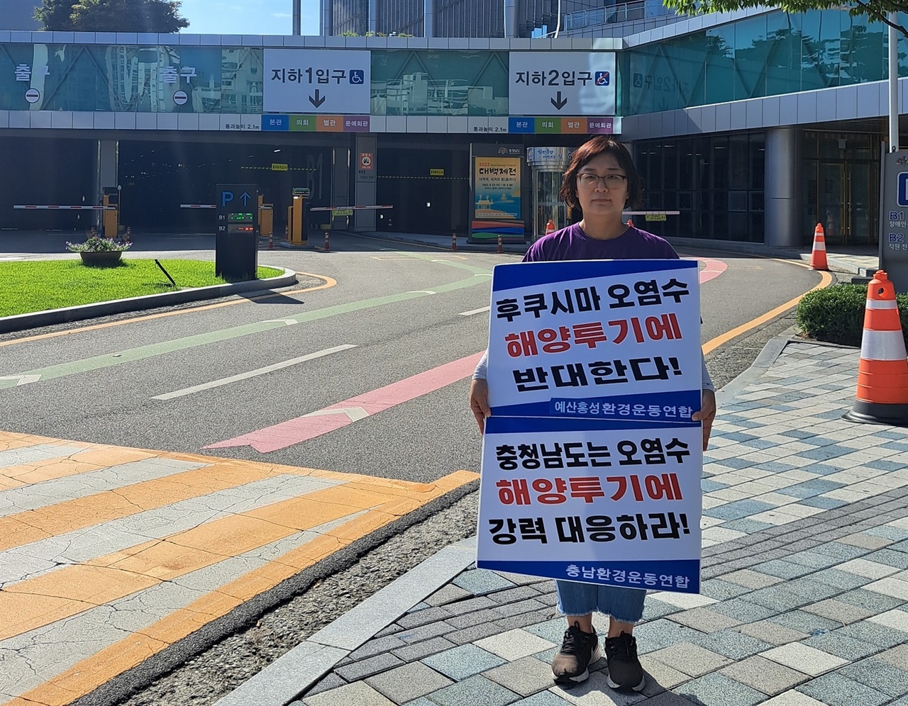 충남환경운동연합 김미선 활동가가 피켓을 들고 충남도청 앞에서 후쿠시마 방사능 오염수 해양투기 강력대응을 촉구하고 있다. 