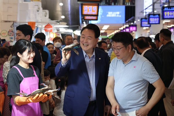 윤석열 대통령이 8월 31일 서울 동작구 노량진수산시장을 찾아 꽃게를 구매하며 상인과 대화하고 있다.

