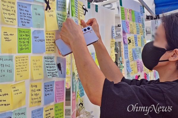 서이초 사망 교사의 49재 날인 4일 오전, 서울 양천구 A초등학교(8월 31일 교사 사망)에 마련된 추모공간에서 한 추모객이 추모 메시지를 담은 메모지를 붙이고 있다. 