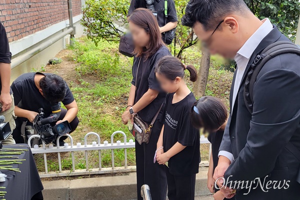 서이초 사망 교사 49재 날인 4일 오전, 한 가족이 서울 서초구 서이초에 마련된 추모공간을 찾아 고인을 애도하고 있다. 