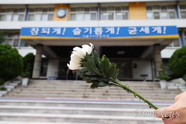 서이초 교사 49재를 맞은 지난 4일 오후 서초구 서이초에서 교사와 시민들이 헌화를 하기 위해 국화꽃을 들고 줄을 서 있다.