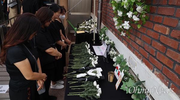  서이초 교사 49재를 맞은 4일 오후 서초구 서이초에서 교사와 시민들이 교실과 가까운 곳에 마련된 추모장소에서 헌화 묵념하고 있다.