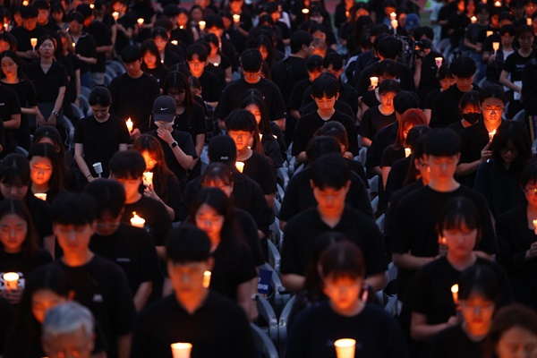 서울 서이초등학교 교사의 49재 추모일인 지난 9월 4일 오후 서울 서초구 서울교육대학교에서 열린 촛불문화제에서 참가자들이 묵념하고 있다.