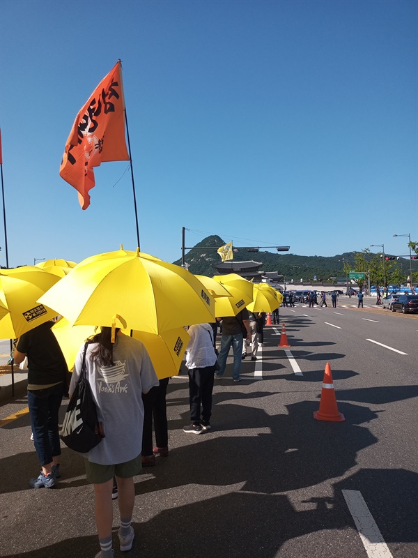 후쿠시마 핵 폐수 방류 반대 문구가 적힌 노랑 우산을 들고 행진 중인 도보 순례단