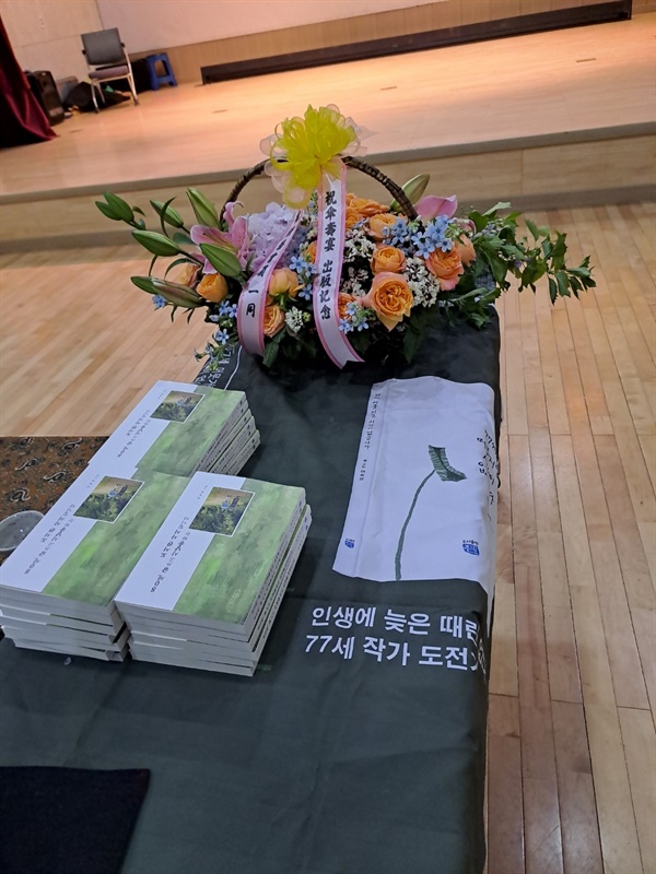 새로 출간한 책과 축하 꽃바구니. 새로 나온 책을 회원들에게 선물 주기 위해 쌓아 놓았다.