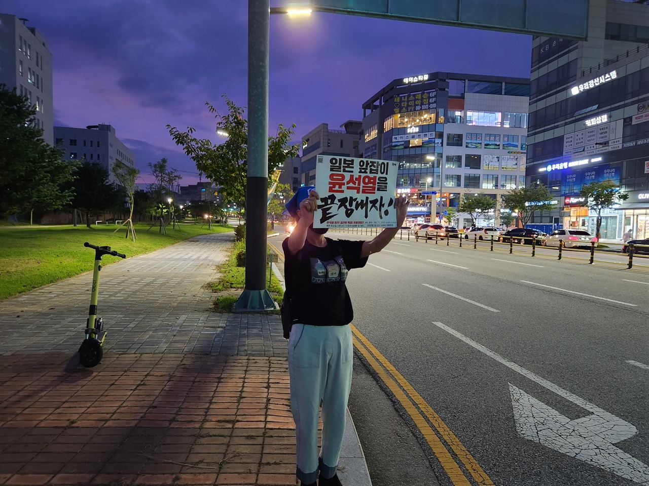 한 시민이 윤석열 대통령을 비판하는 내용의 피켓을 들고 있다. 