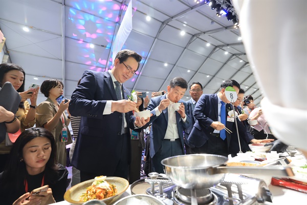 정황근 농림축산식품부 장관이 15일 전북 익산에서 열리는 엔에스(NS)푸드페스타를 방문, 국산 식품 원료인 가루쌀로 만든 제품을 참석자들과 함께 직접 시식하며 홍보하고 있다.