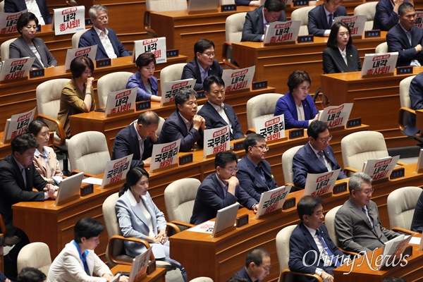 더불어민주당 의원들이 18일 서울 여의도 국회 본회의장에서 한덕수 국무총리 해임을 요구하는 피켓을 불이고 있다.