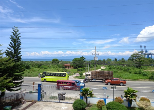 판-필리핀 고속도로 너머로 다바오만이 푸른 하늘에 구름을 피워 올리고 있다.