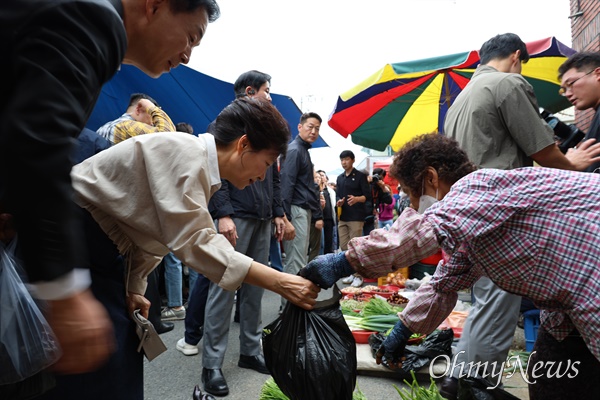 전직 대통령 박근혜씨가 추석을 앞둔 25일 오전 자신의 집 근처인 현풍시장을 찾아 고구마줄기와 호박잎을 사고 있다.