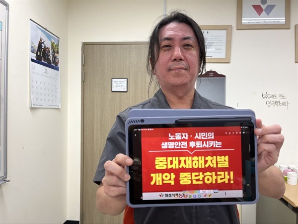 화섬식품노조 조합원이 "중대재해처벌법 개악 중단하라" 손피켓을 들고 있다. 