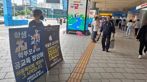 27일 오전 서울역에서 1인 시위에 참가한 교사가 귀성객들을 상대로 공교육 정상화와 억울한 교사 죽음 진상규명을 호소하는 피켓을 들고 있다. @조광현