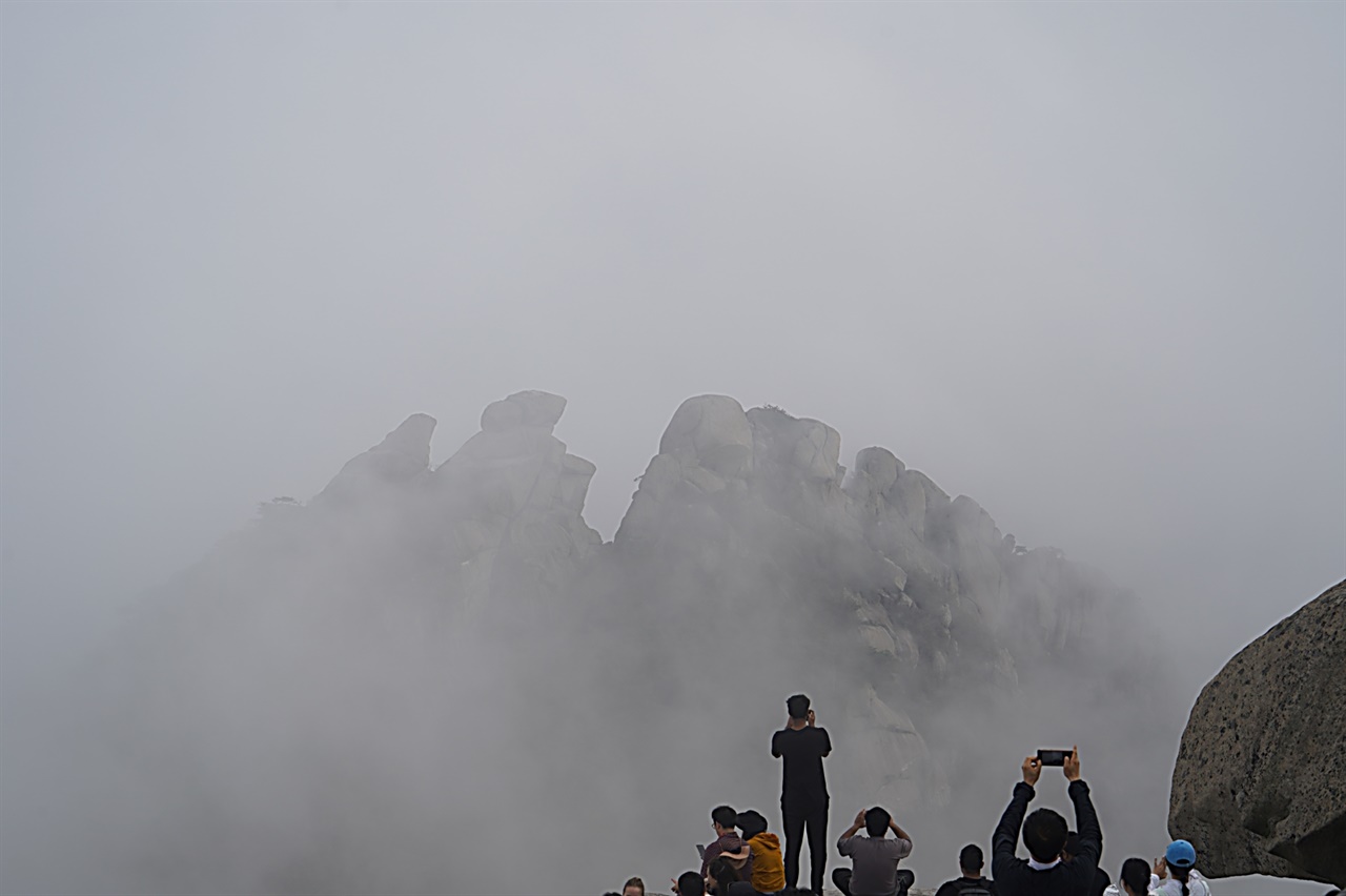 구름에 덮힌 만경대가 잠시 구름이 걷히자 사람들이 사진을 찍고 있다.