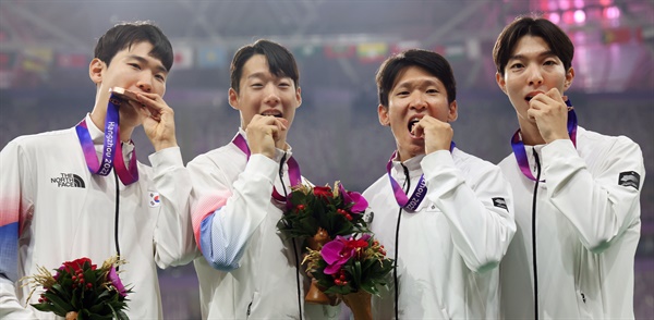  3일 중국 항저우 올림픽 스포츠센터에서 열린 2022 항저우 아시안게임 남자 육상 400ｍ 계주 결선에서 동메달을 획득한 한국 고승환(왼쪽부터), 이재성, 김국영, 이정태가 시상대에 올라 메달을 입에 물어보는 포즈를 취하고 있다.