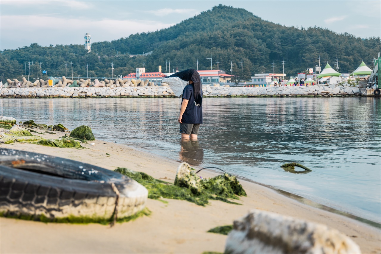 고래탈을 쓴 시셰퍼드 코리아 활동가가 오염된 바다를 멍하니 바라보고 있다.