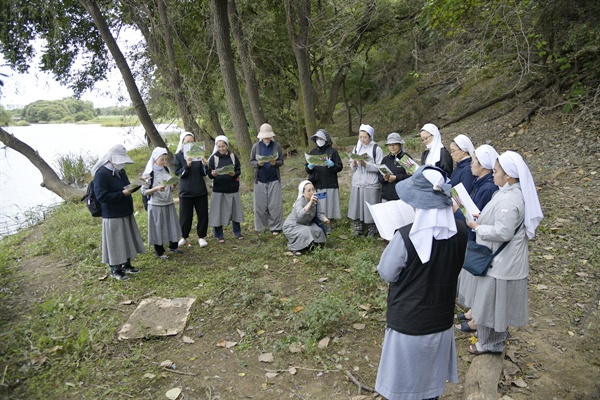 왕버들숲에서 연극대본 <팔현 반상회>를 읽고 있는 수녀들