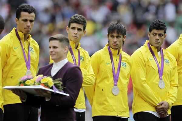  2012 런던 올림픽에서 브라질 선수들에게 메달을 전달하는 남자 도우미.
