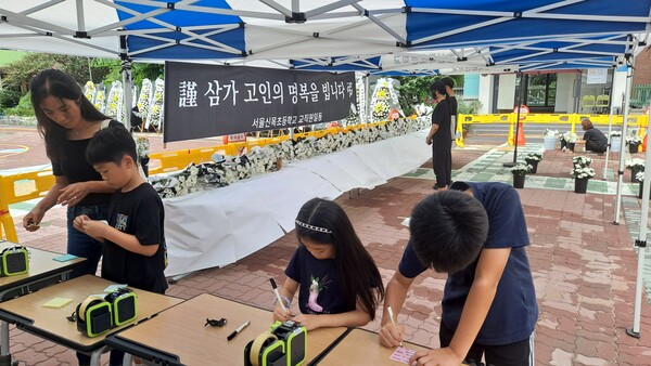 4일 오전 서울 신목초 정문 안쪽에 마련된 분향소에서 분향을 마친 추모객이 고인에게 남길 메시지를 작성하고 있다. @조광현
