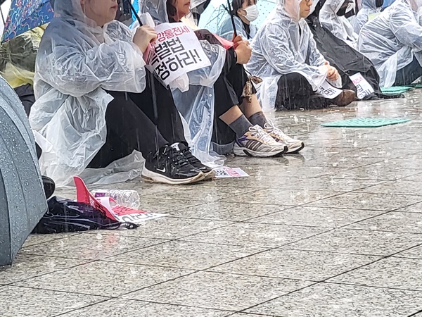 14일 전세사기 피해자들이 장대비 속에서 서울 종로구 보신각 앞에서 열린 전국 전세사기·깡통전세 피해자 집중 집회에 참석하고 있다.