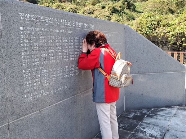 2023년 10월 23일 경북 경산시 코발트광산 희생자 위령탑 뒤에 새겨진 위패 앞에서 유족이 눈물을 흘리며 “아버지”를 부르고 있다.
