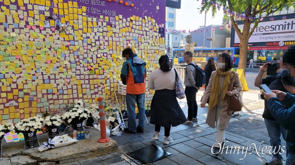 이태원 참사 1주기를 하루 앞둔 28일, 참사 장소인 서울 용산구 이태원역 인근 골목을 찾은 시민들이 추모 메시지를 읽거나 적고 있다. 