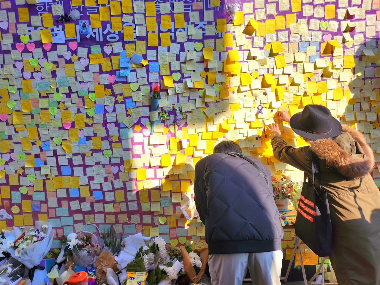 이태원 참사 현장에 마련된 추모 공간에서 시민들이 포스트잇을 붙이고 있다.