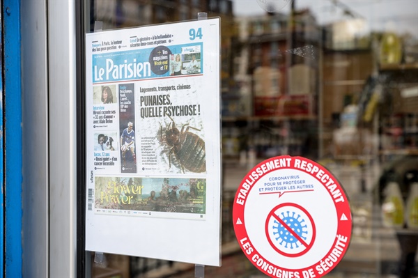 지난 10월 4일 프랑스 파리의 한 해충 퇴치 업체가 파리의 빈대 문제를 다룬 지역 신문 <르 파리지앵> 1면을 가게 문 앞에 붙여놓고 있는 모습. 