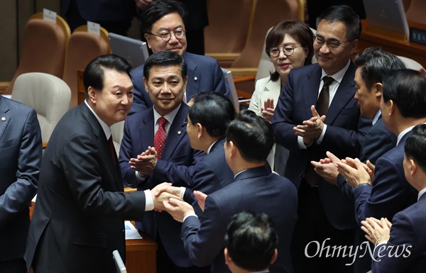  윤석열 대통령이 31일 오전 국회 본회의장에서 내년도 정부 예산안에 대한 시정연설을 마친 뒤 국민의힘 의원들과 악수하고 있다.