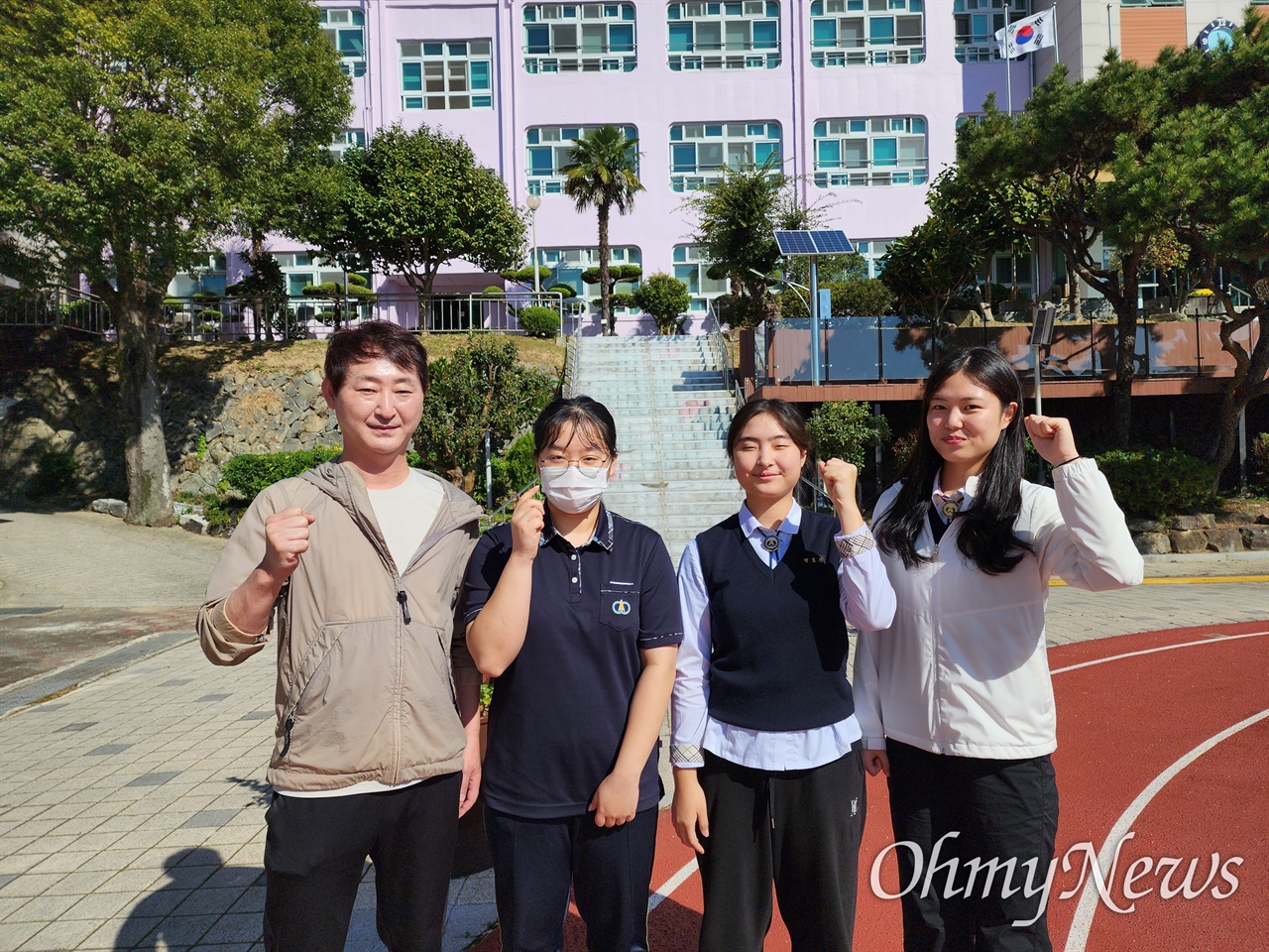 김현호 코치와 김연서, 김의주, 박예은 학생이 교정에서 여수여고 화이팅을 외치고 있다 