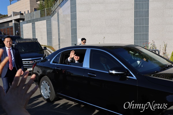 윤석열 대통령이 7일 오후 전직 대통령 박근혜씨를 만난 후 차를 타고 나오며 시민들을 향해 손을 흔들고 있다.