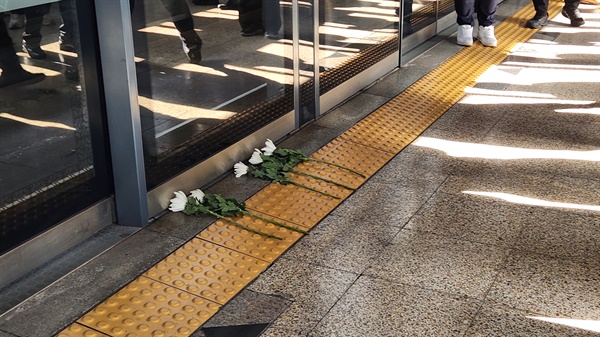 구의역 9-4 승강장 앞에 국화꽃이 놓여 있다. 