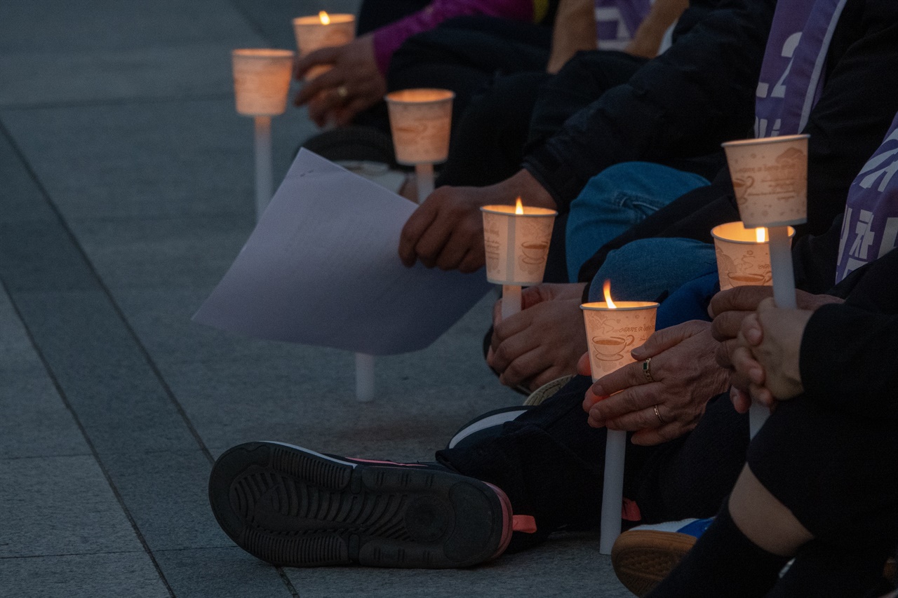 풍남문 광장 앞 이태원 참사 추모제에서 촛불을 들고 있는 유가족들의 손