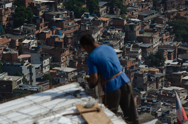 지난 17일 브라질 리우 데 자네이루의 폭염 속에서 로시냐 빈민가 주민이 건설 현장에서 일하고 있다.
