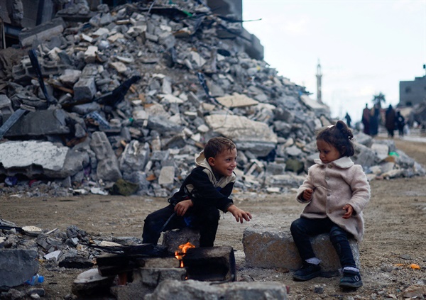 11월 27일(현지시간) 가자지구 남부 칸 유니스에서 어린이들이 건물 잔해 주변에 피워진 불 옆에 앉아 있다. 이스라엘과 팔레스타인 무장 정파 하마스는 30일 오전까지 이틀간 일시 휴전을 연장하기로 합의했다.