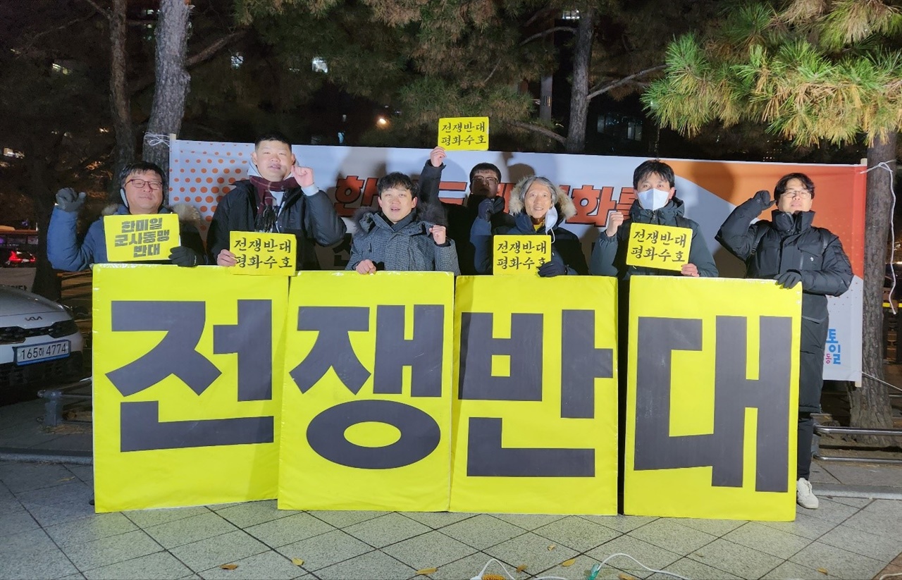 11월 29일 서울 보신각 앞에서 열린 수요평화촛불 참가자들이 ‘전쟁반대’, ‘전쟁반대 평화수호’ ‘한미일 군사동맹 반대’ 피켓을 들고 있다. 