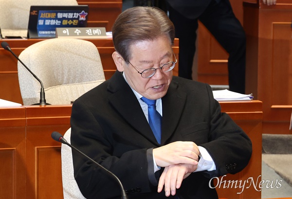 이재명 더불어민주당 대표가 30일 오후 서울 여의도 국회에서 열린 의원총회에 참석해 개회를 기다리며 시계를 보고 있다.